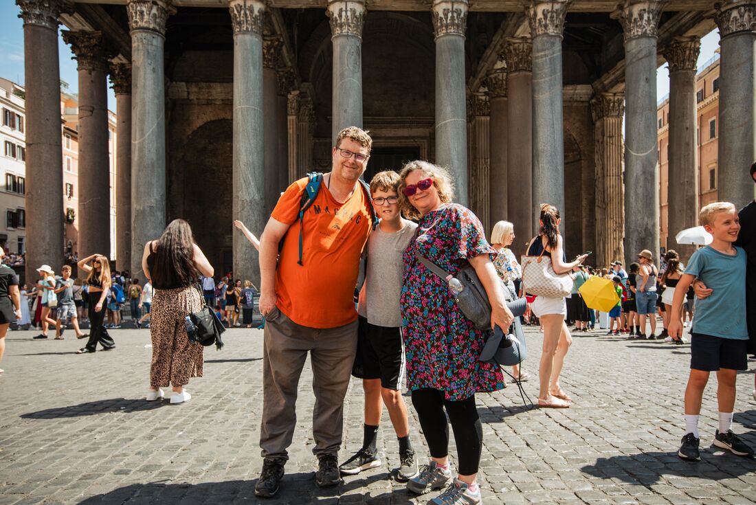 Intrepid traveller family posing for a photo in the streets of Rome outside the Pantheon in Italy