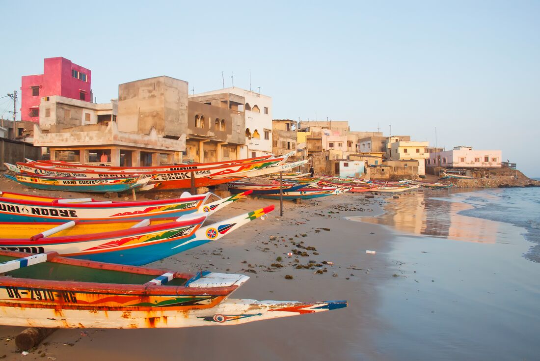 Traditional colourfully painted fishing boats on the beach of Dakar in Senegal