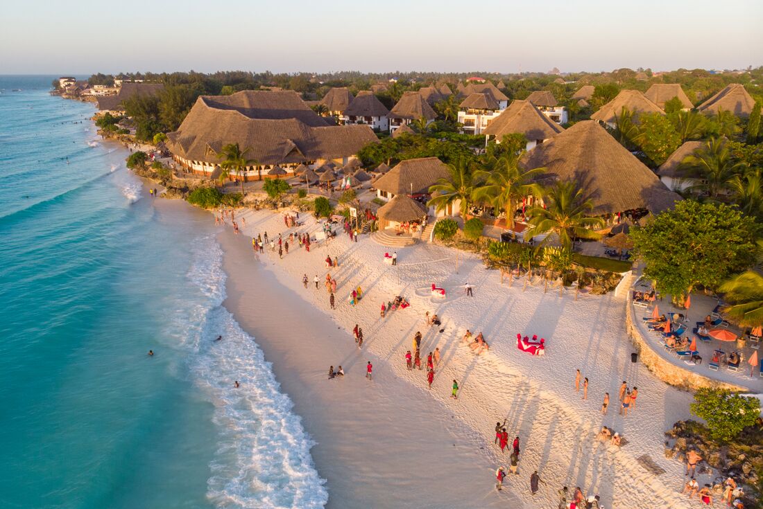 Nungwi Beach on Zanzibar island on the coast of Tanzania with locals and travellers gathered at sunset