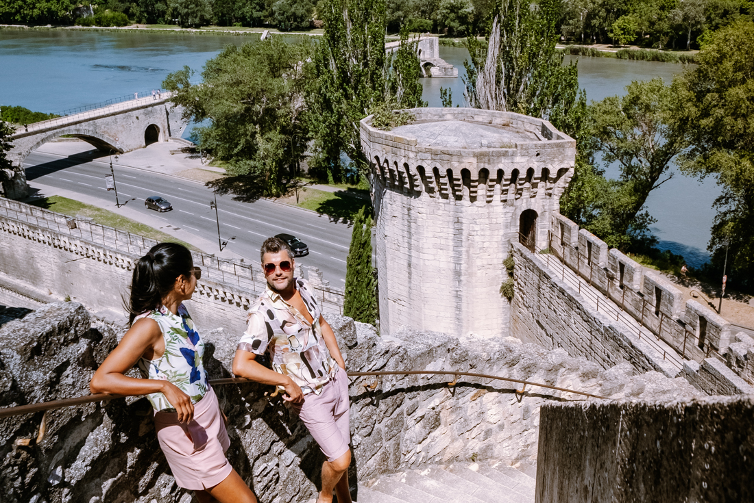 Travellers stop to rest on the stairs of a medieval castle in Avignon France