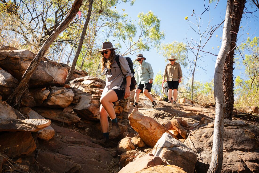 Leader descending rocky trail followed by travellers on the Manning Falls Hike in Western Australia