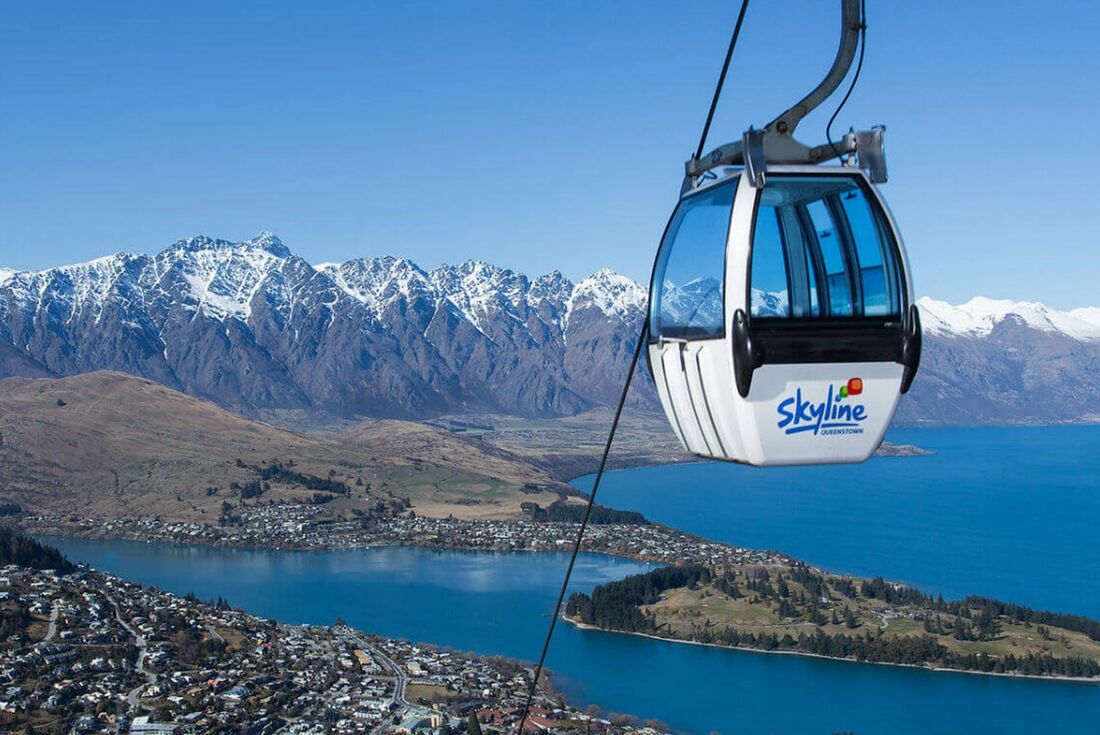 Skyline gondola in front of Queenstown landscape of vast mountains in the background, New Zealand