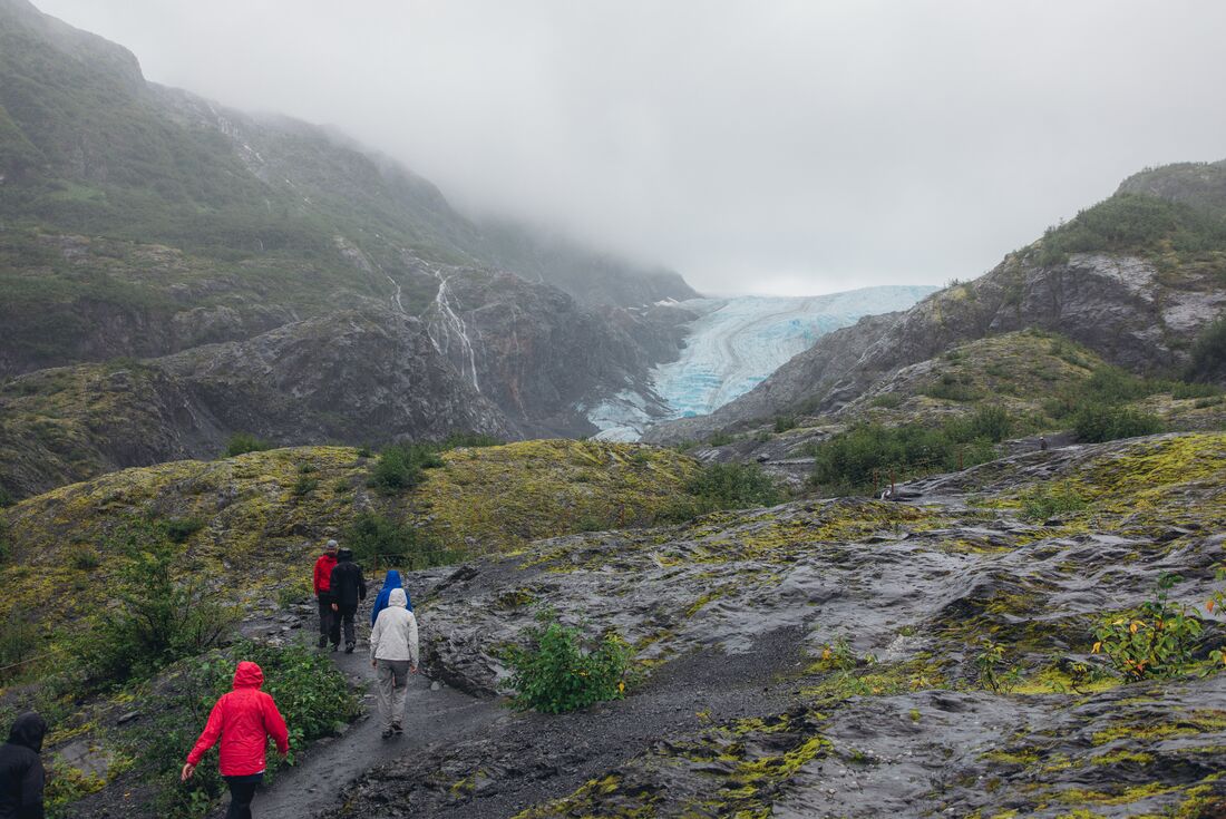 Travellers and leader hiking toward Exit Glacier in the mountains near Seward Alaska 