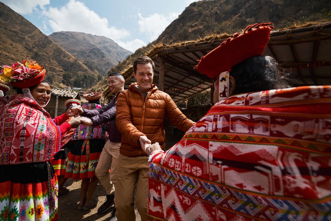 Intrepid travellers enjoy a dance with women of the Huilloc Community in Sacred Valley 