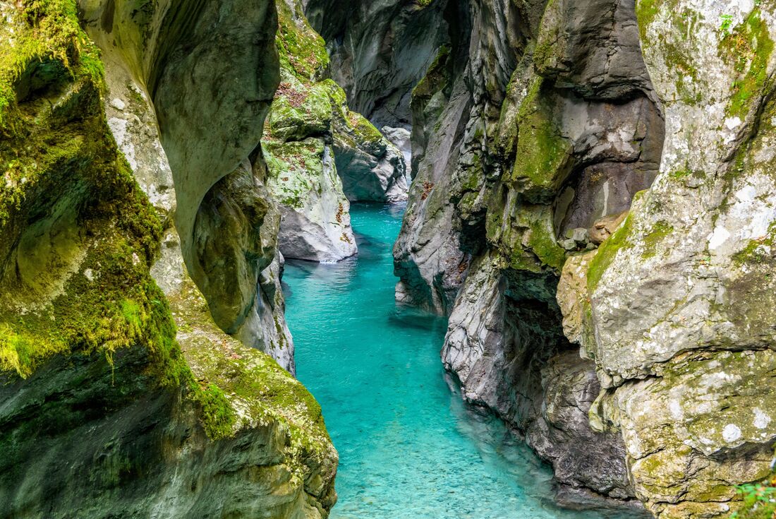 The depths of Tolmin Gorges with crystal blue waters running through wind carved stone walls