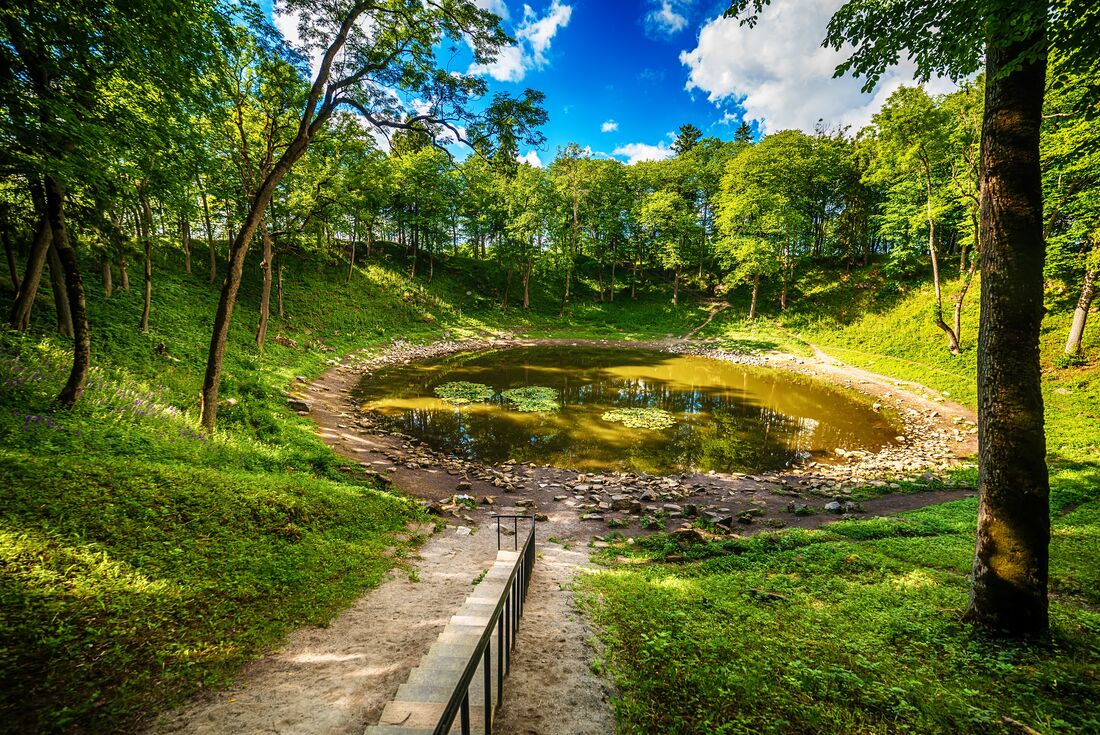 Water pooled in Kaali meteorite crater in Saaremaa forest in Latvia