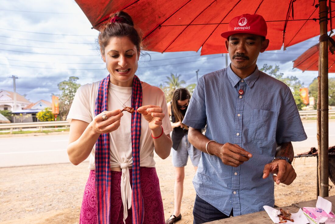 Traveller trying street food with Leader in Siem Reap, Cambodia