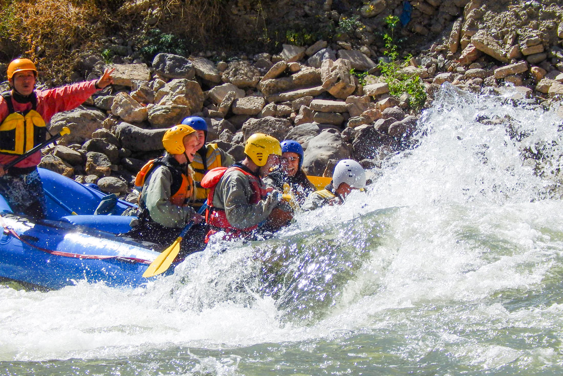 Travellers in a whitewater raft go directly into the rapids near Ollantaytambo