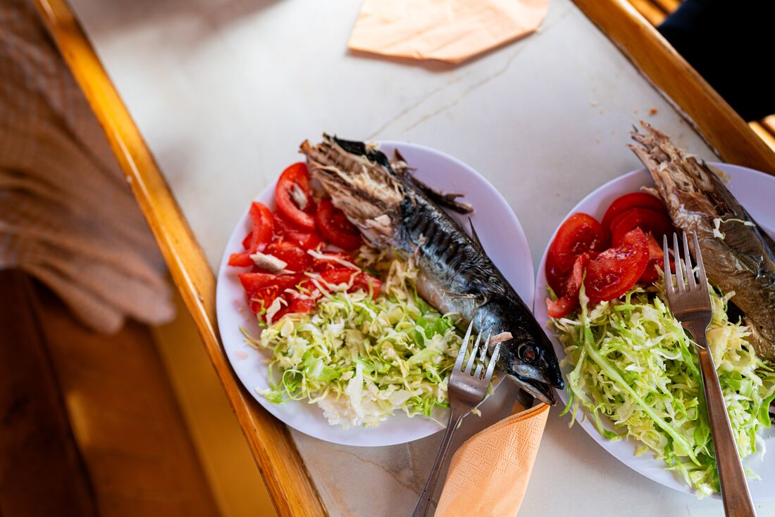 Fresh whole cooked fish with greens and salad served on Hvar Island, Croatia, Dalmatian Coast
