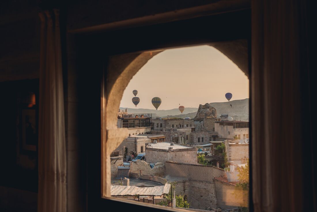 Hot air balloons go up with the sunrise seen from accomodation in Cappadocia in Turkey