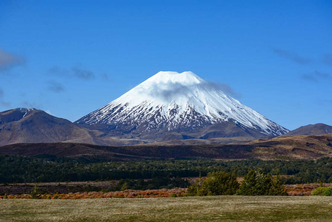 Wide view of Mount Ruapehu against a blue sky backdrop in Tongariro National Park, New Zealand