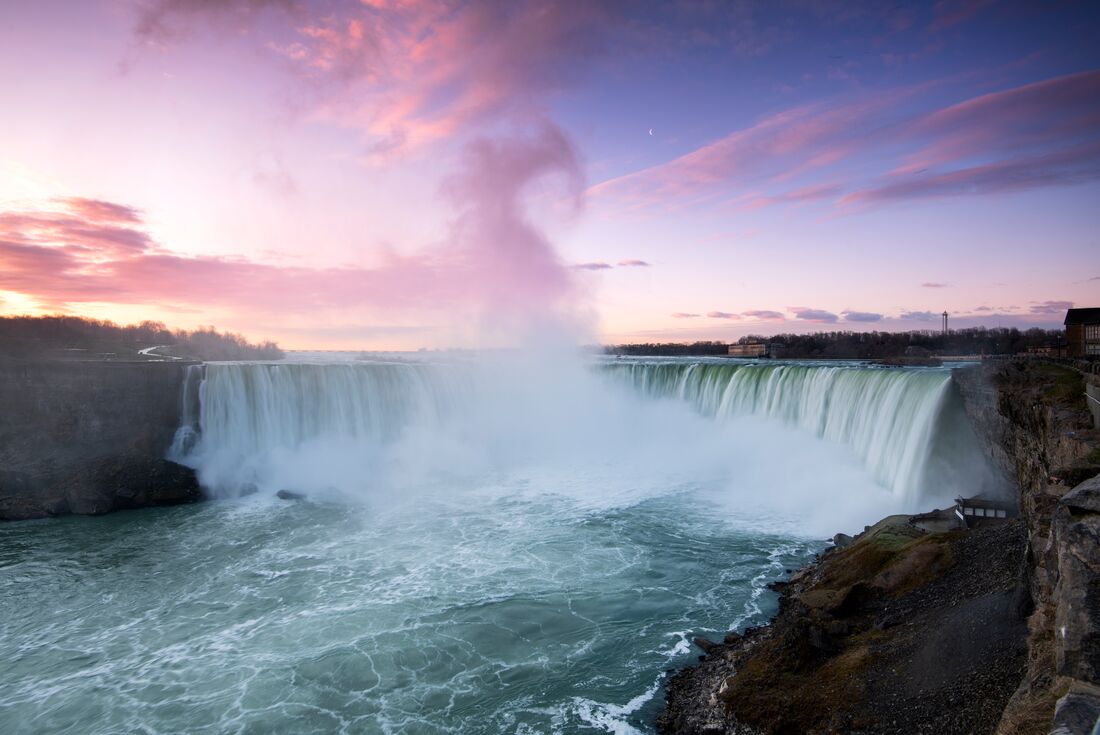 Gentle mist drifts off Niagara Falls at sunset in southern Canada