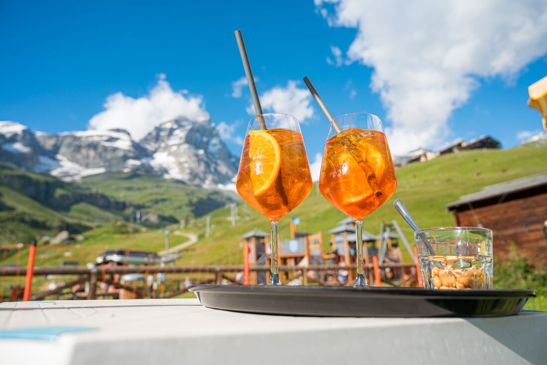 Orange cocktails served for an apertif on a balcony in the Italian Dolomites
