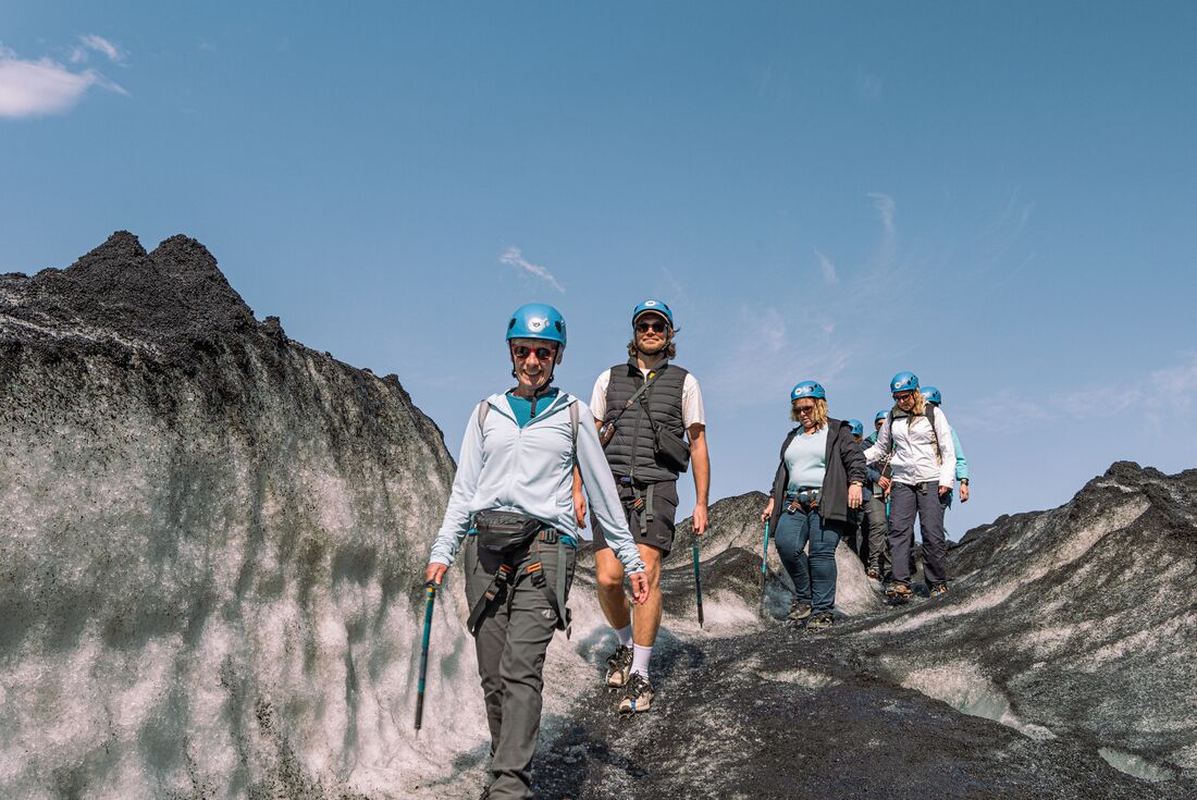 Group of travellers happily glacier hiking in Solheimajokull