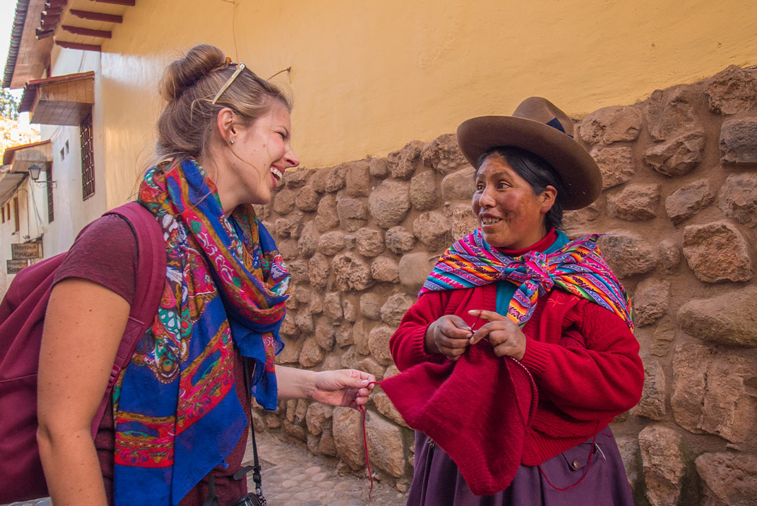 Traveller talking to local woman, Cusco, Peru