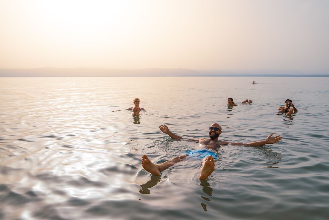Intrepid travellers and leader floating in the Dead Sea in Jordan