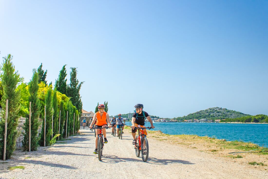 Travellers cycling the coast of an island in southern Croatia